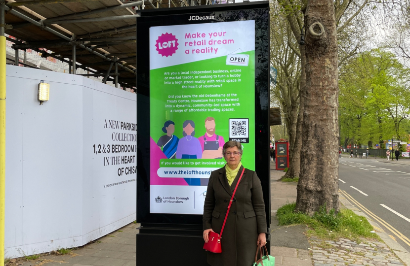 Cllr Biddolph standing in front of an existing hoarding showing its enormous scale. It is twice her height and more than twice her width (and she's podgy!). 