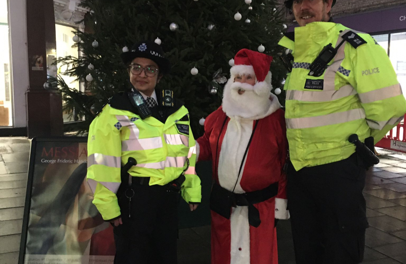 Sergeant Jim Cope and PC Durr-e- Tariq standing beside the glittering just-lit tree