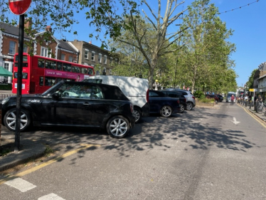 Car park seen from the west, a bus in the background and the George IV pub sign in the distance