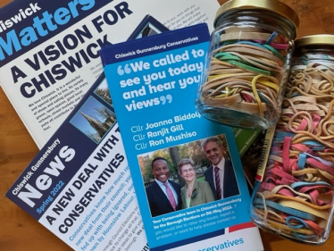 Three leaflets and two glass jars of rubber bands, saved to wrap round bundles of leaflets